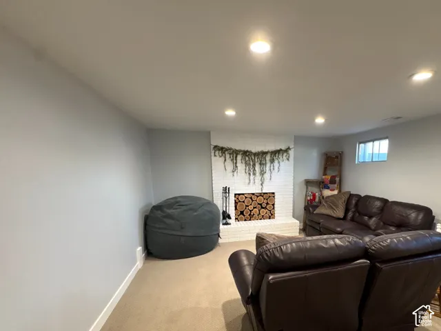 Painted brick fireplace featuring a raised hearth and recessed lighting