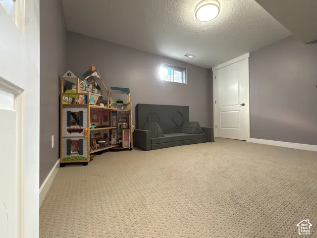 Neutral-toned interior room featuring wall-to-wall carpeting, a recessed ceiling light, an egress window, and a paneled interior door