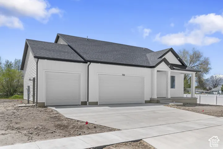 Single-story exterior with vertical siding, gable roofline, covered front porch with column supports, and a three-car garage