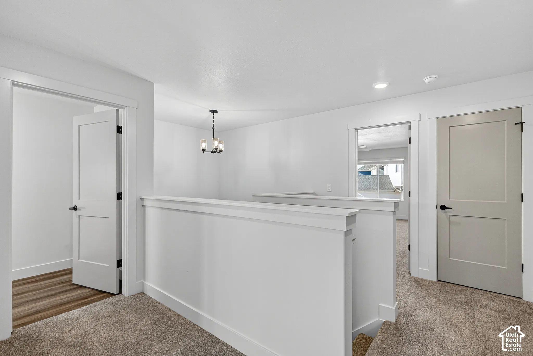 Neutral-toned interior featuring shaker-style interior doors, modern multi-light chandelier, and wall-to-wall carpeting
