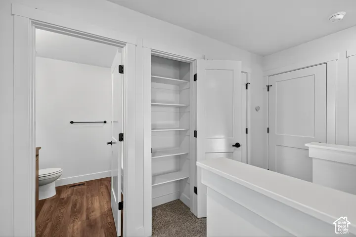 Built-in shelving unit with white finish, solid-core doors with matte black hardware, wood-finish flooring, and crisp white trim detailing