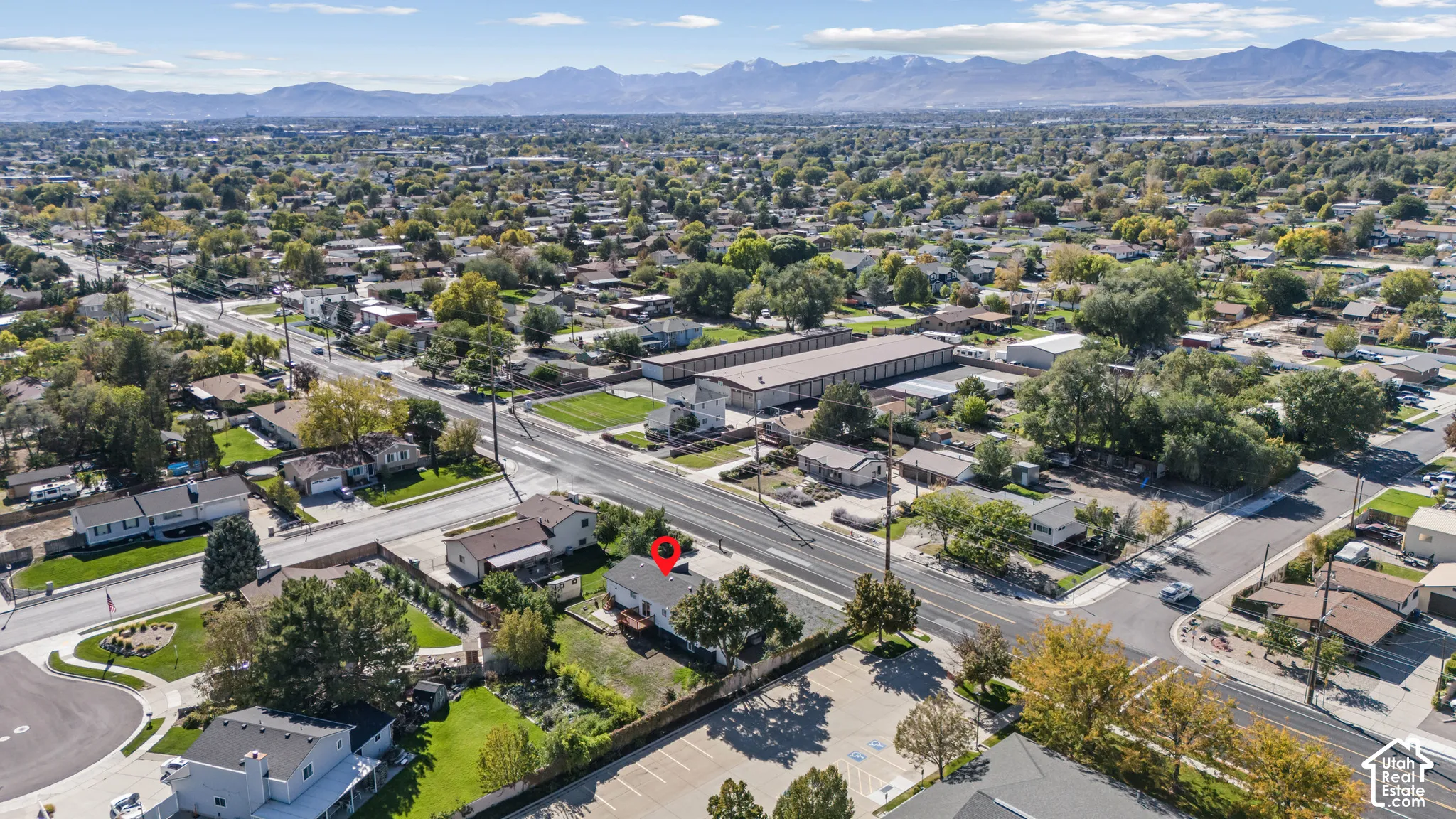 Aerial perspective featuring a detached residential structure, mature landscaping, and prominent mountain backdrop