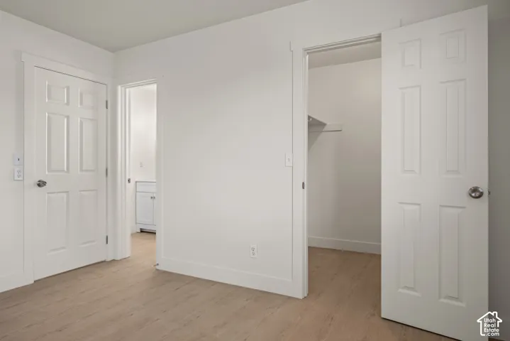 Wood-finish flooring, white six-panel interior doors, and built-in closet shelving