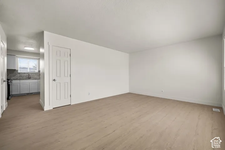 Interior space featuring neutral wall paint, wood-finish flooring, and a six-panel door