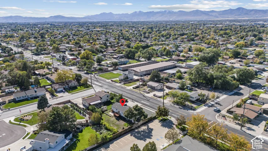 Aerial perspective featuring a detached residential structure, mature landscaping, and prominent mountain backdrop