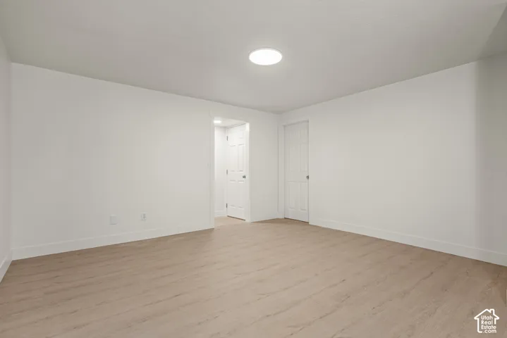 Interior space featuring neutral wall paint, wood-finish flooring, and recessed ceiling lighting with two paneled interior doors