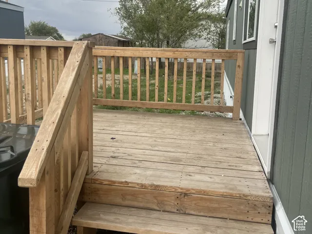 Elevated wood deck featuring vertical railing and built-in wooden stairs
