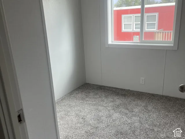 Neutral-toned walls paired with grey carpeting and a sliding window