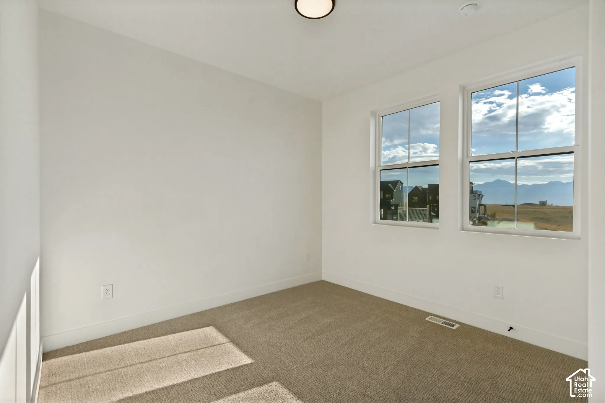 Neutral-toned carpeting, dual pane windows, and mountain scenery
