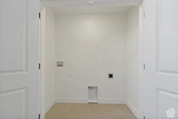 Dedicated utility alcove featuring dual paneled swing doors, neutral tile flooring, and integrated plumbing and electrical hookups