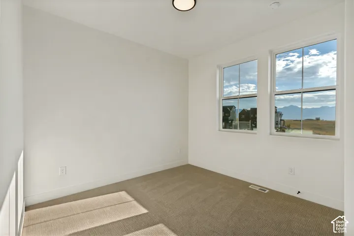 Neutral-toned carpeting, dual pane windows, and mountain scenery