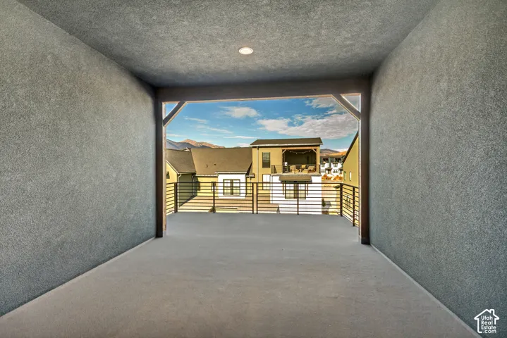 Covered deck featuring stucco walls, recessed lighting, and horizontal metal railings