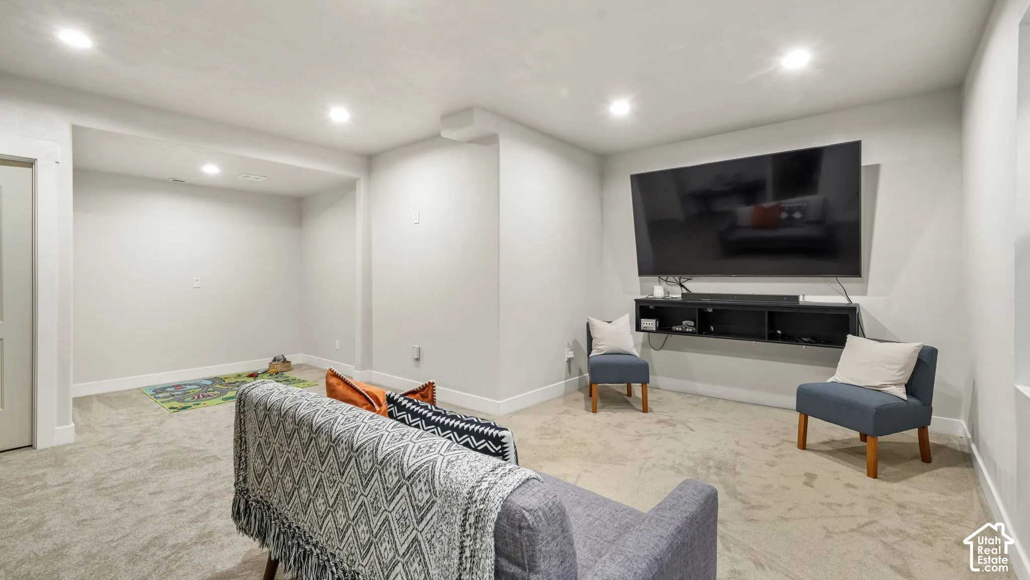 Basement flex room featuring recessed ceiling lighting, wall-to-wall carpeting, and a wall-mounted floating media console