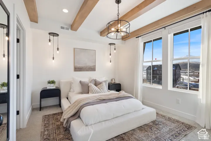 Exposed wood ceiling beams, decorative chandelier lighting, wall-mounted pendant lights, and large multi-pane windows