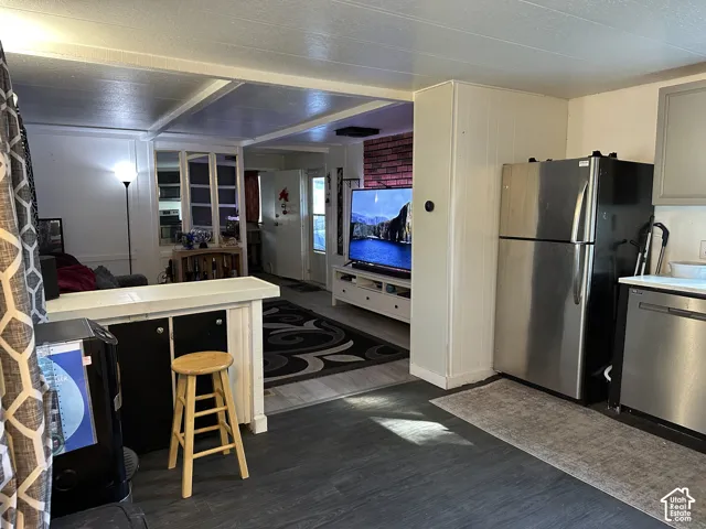 Kitchen has contrasting flooring, stainless steel dishwasher and stove