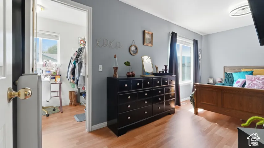 Bedroom featuring wood-finish flooring, dual-pane windows, and neutral wall tones