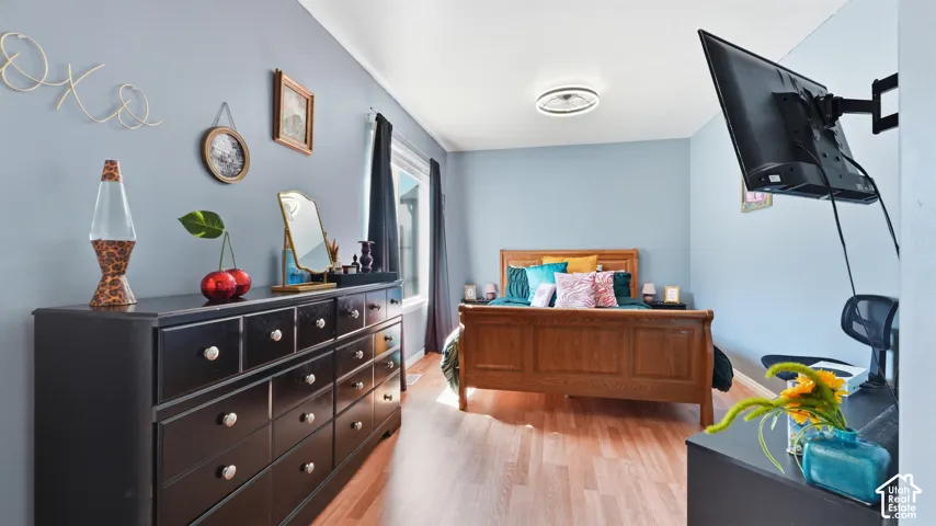 Wood-finish flooring, light blue wall paint, and a circular LED flush-mount ceiling light fixture