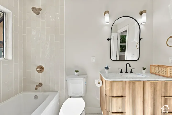 Fluted-wood vanity with stone countertop, arched-frame mirror, matte black fixtures, and vertical tile shower surround