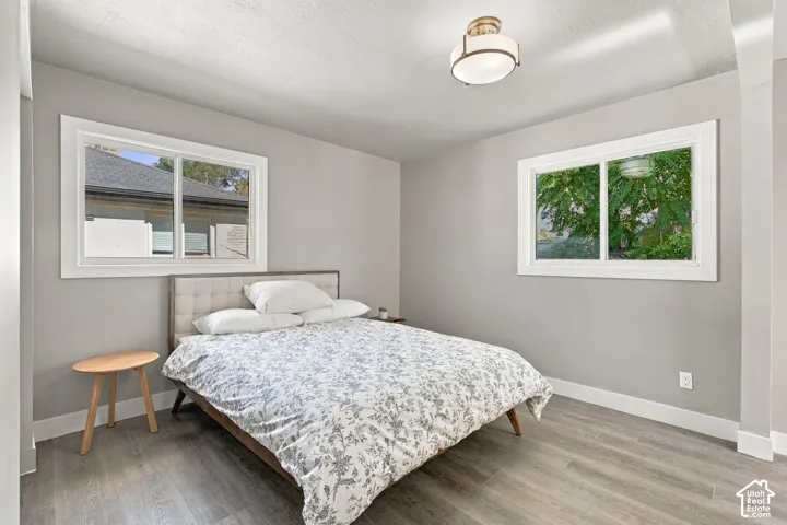 Neutral-toned interior featuring wood-finish flooring, two sliding windows, and a flush-mount drum ceiling light fixture