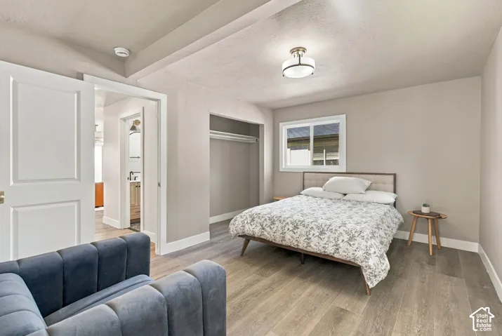 Wood-finish flooring, neutral wall tones, semi-flush mount ceiling lighting, and a built-in closet with overhead shelving