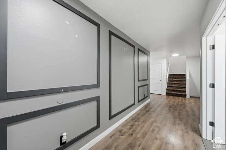 Hallway featuring wood-finish flooring and decorative wall molding