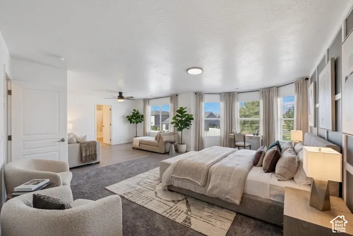 Spacious interior featuring a multi-panel accent wall, large bay windows, recessed ceiling lighting, and a ceiling fan