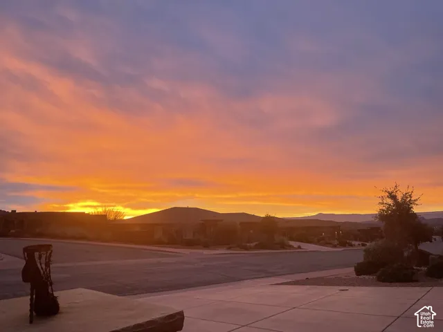 Concrete driveway and hardscaped exterior grounds set against a prominent mountain backdrop at sunset