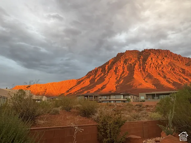 Exterior structures featuring multi-level balconies and expansive glass windows set against a backdrop of a prominent red rock mountain