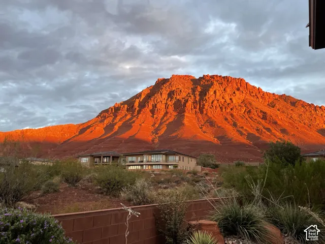 Two-story residential structure featuring multiple balconies and a prominent mountain backdrop