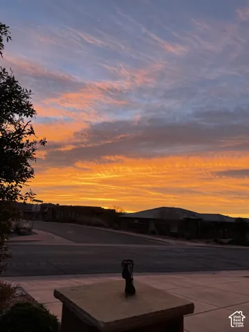 Stone-capped pillar and paved concrete walkway under a scenic sunset sky
