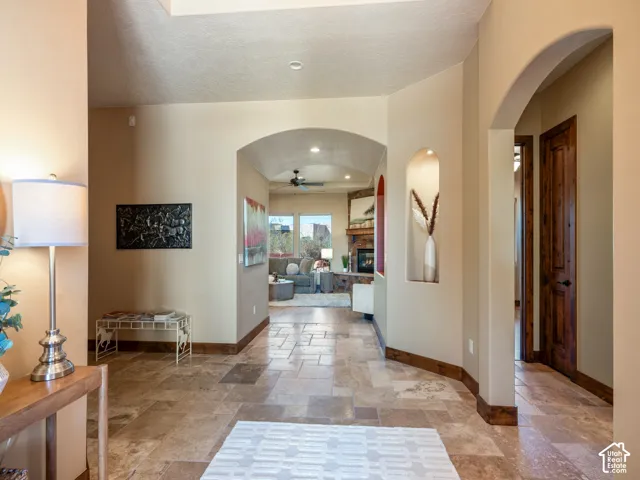 Entryway featuring stone-tile flooring, arched architectural detailing, built-in display niche, and stained wood trim