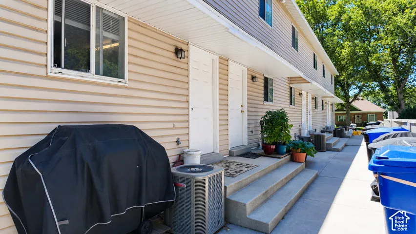 Multi-unit exterior featuring horizontal siding, concrete entry steps, and exterior wall-mounted light fixtures