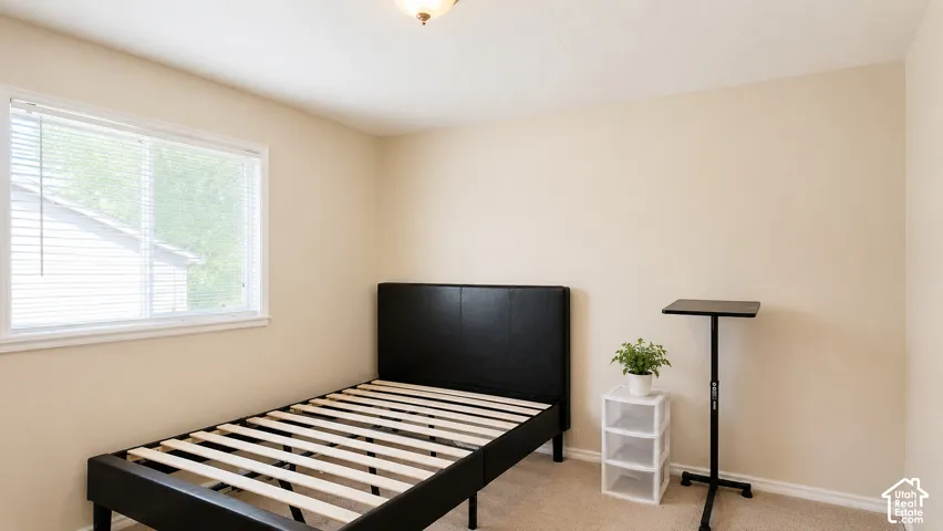 Neutral-toned walls, wall-to-wall carpeting, and a window with horizontal blinds