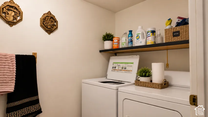 Laundry area featuring a wall-mounted shelf with black metal supports and a wooden towel rack