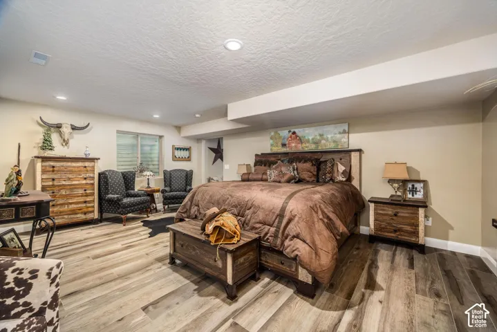 Wood-finish flooring, recessed lighting, and neutral wall paint