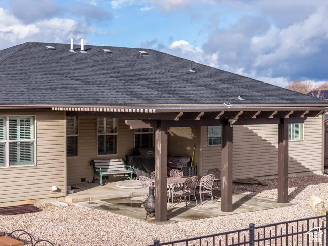 Rear exterior featuring a covered patio with a wooden pergola, concrete slab flooring, and horizontal siding