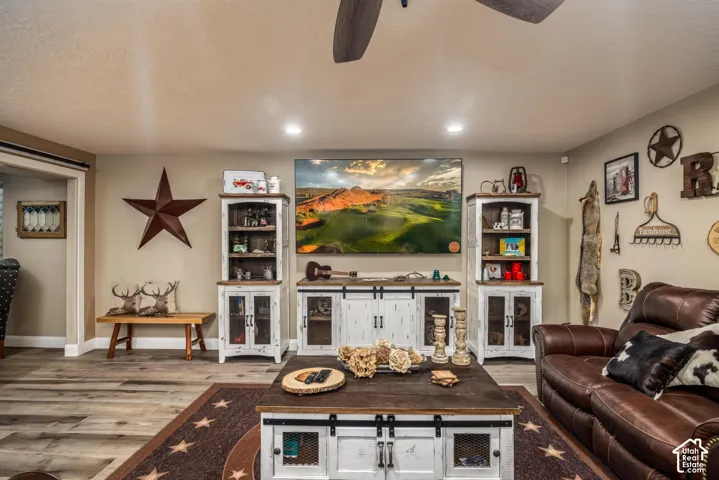 Living space featuring wood-finish flooring, recessed lighting, and a ceiling fan