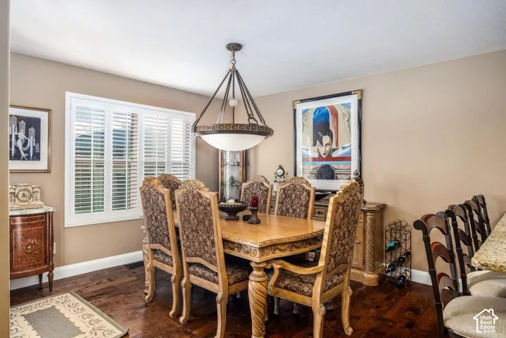 Wood-finish flooring, plantation shutters, and a central multi-arm drum pendant light fixture
