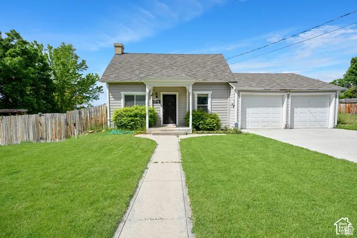Single-story residence featuring horizontal siding, a covered entryway with decorative millwork, an attached two-car garage, and a concrete driveway