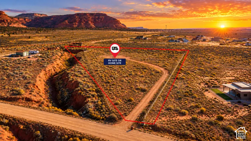 Sunrise on an expansive lot featuring natural desert landscape, topographical rock formations, direct dirt road access, and mountain scenery