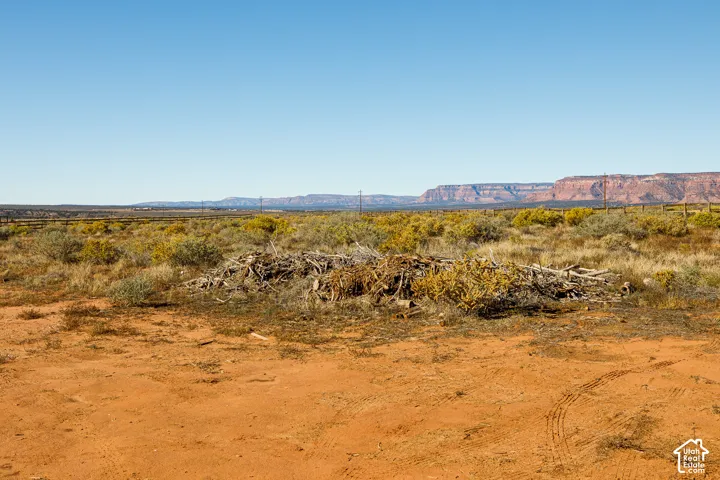 Expansive desert landscape featuring native brush, earthen terrain, and prominent mountain formations