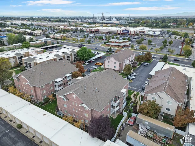 Aerial perspective featuring multi-story brick and stucco building exteriors, asphalt shingle roofing, surface parking lots, and covered carport structures