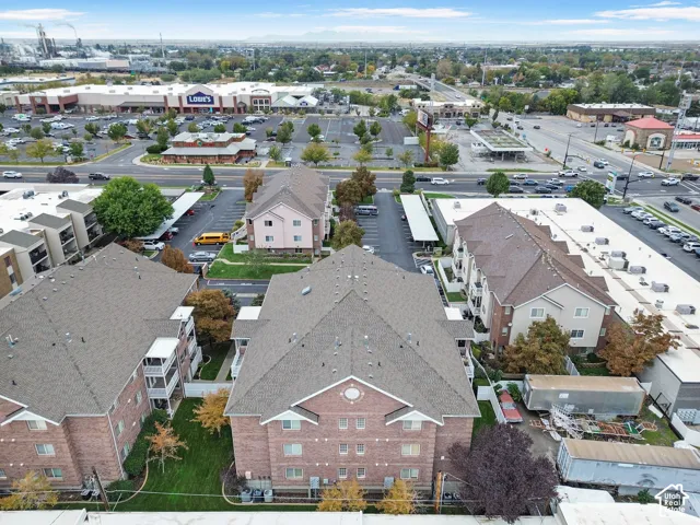 Multi-story brick building featuring asphalt shingle roofing, private carports, and integrated exterior ground-level HVAC units