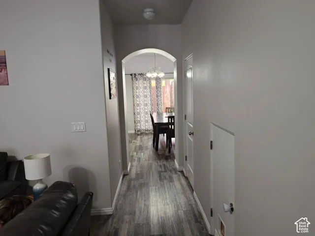 Arched entryway featuring wood-finish flooring, neutral wall paint, and interior doors with brushed metal hardware