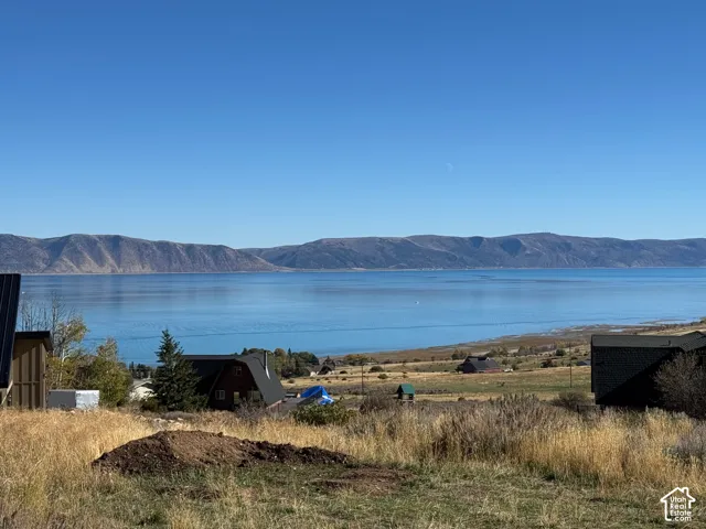 Expansive water frontage featuring a panoramic mountain backdrop and rolling natural terrain