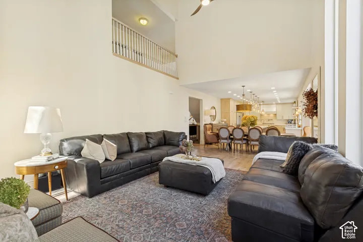 Double-height ceiling, wood-finish flooring, and white railing balcony overlooking the main level