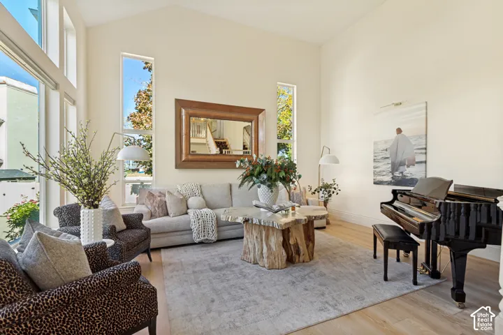Vaulted ceiling, wood-finish flooring, and expansive vertical windows