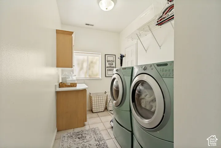 Laundry room featuring tile flooring, built-in cabinetry with stone-surface countertop, and overhead wire shelving