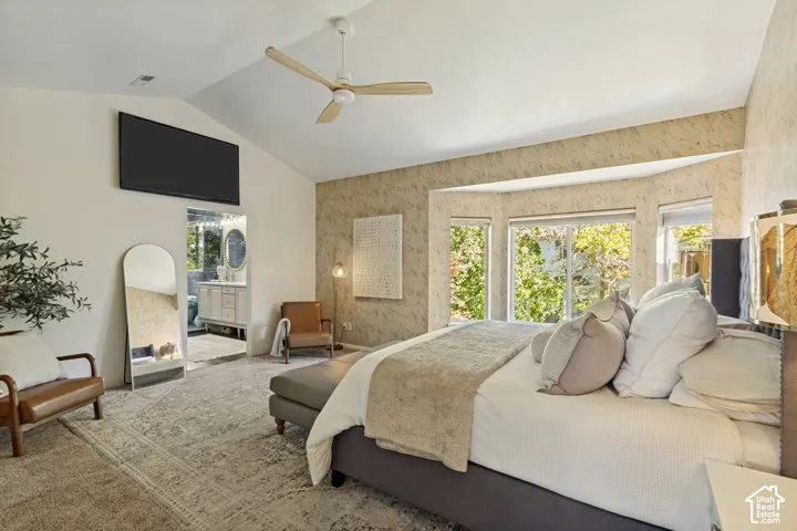 Vaulted ceilings, bay window with exterior foliage, and ceiling fan