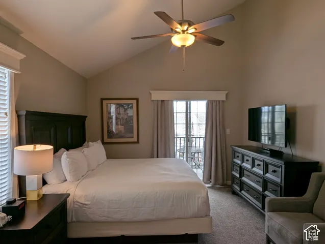 Primary bedroom with vaulted ceiling, ceiling fan with integrated lighting, wall-to-wall carpeting, and sliding glass door with external balcony access